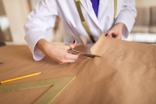 Fashion designer cutting garment patterns