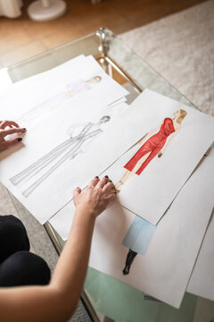 Hands choosing fashion sketches