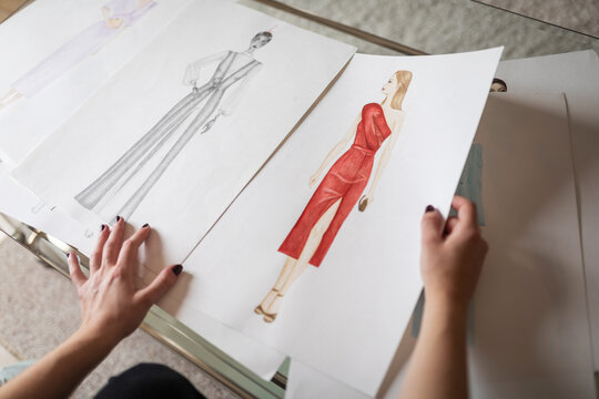 Hands choosing fashion sketches