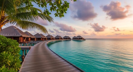 Pathway to overwater bungalows on a tropical island during a beautiful sunset