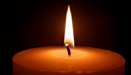 close up of a burning candle flame against a dark background showing candlelight light and fire