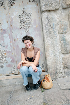 young woman sitting by aport int he city of Porto, Portugal