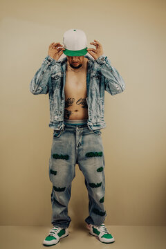 Hombre posando y luciendo outfit callejero y aesthetic para fotograf&iacute;a de moda en estudio 