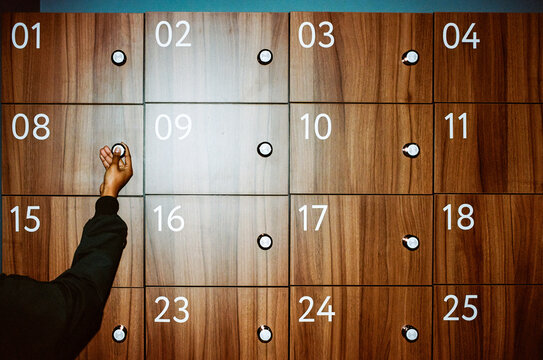 Hand of Person Unlocking Wooden Locker 
