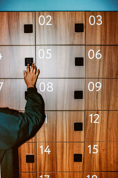 Hand Entering Code on Wooden Locker Keypad