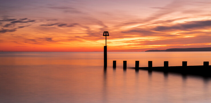 Bournemouth beach illuminated by the setting sun at sunset - Powered by Adobe