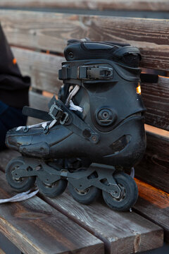 Inline skates resting on wooden bench after skating session