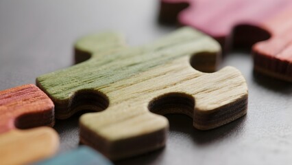 Close up of colorful wooden puzzle pieces autism ADHD neurodiversity inclusion awareness