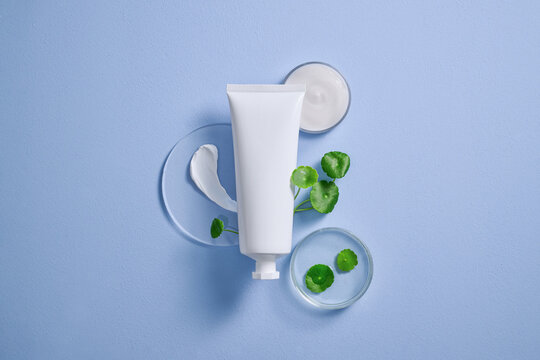 Skincare cream tube and water pennywort leaves