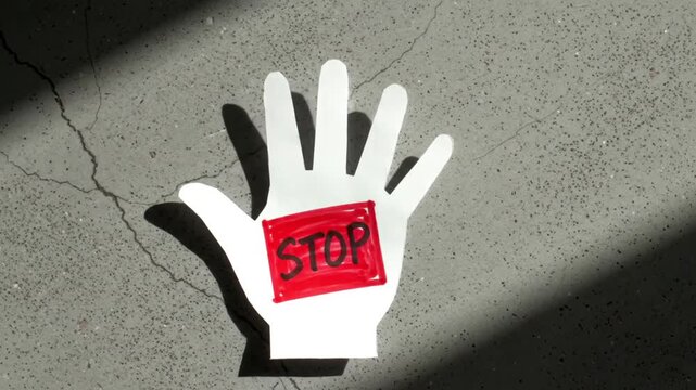 Hand Drawn Paper Stop Sign with Red Square Against a Concrete Background