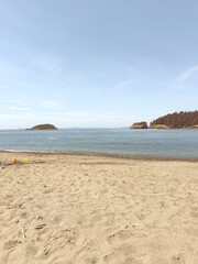 Sandy beach with ocean and small islands in background
