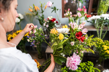 Florist arranging colorful bouquet in flower shop