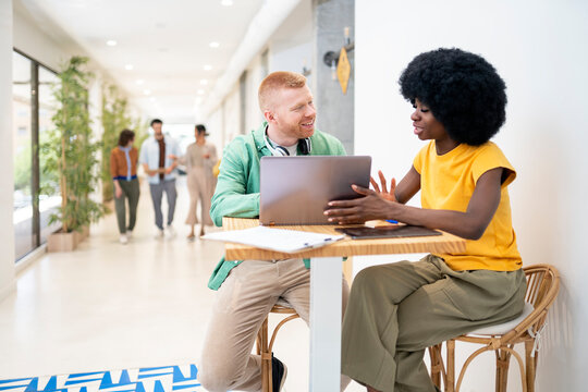 Office workers collaborating on project using laptop and tablet