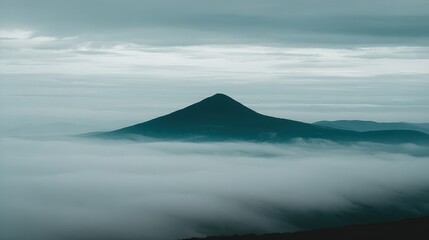 Naklejka premium Dark mountain peak above a sea of clouds.