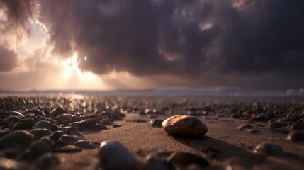 A single, light-brown stone rests on a sandy beach at sunrise.