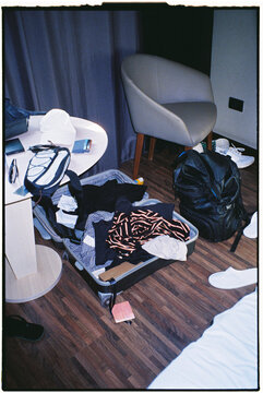 Film image lit with direct flash showing a messy hotel room