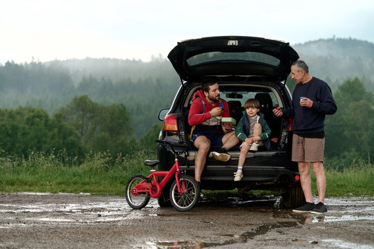 Family snack break by the forest after biking