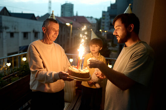 Joyful birthday celebration on a balcony with family