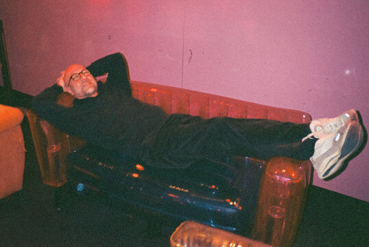 Man Lounging on Transparent Inflatable Sofa in 90's style