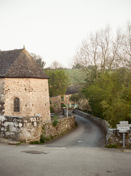 Road defined by ancient short walls in village at golden hour
