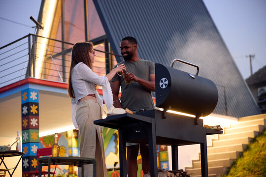 Man and woman toasting while preparing barbecue
