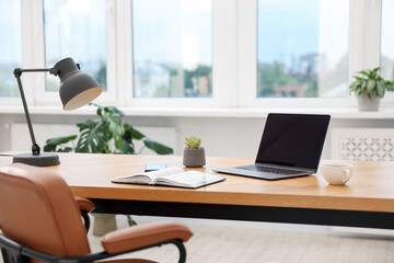Stylish workplace with modern laptop and stationery on wooden desk indoors