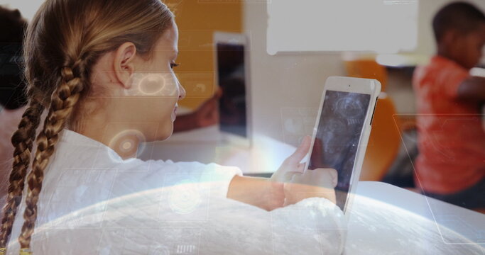 Tapping braided schoolgirl engaging with tablet in classroom, with desks devices