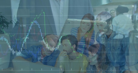 Collaborating office team reviewing data on laptop and tablet at workspace, with chart overlay