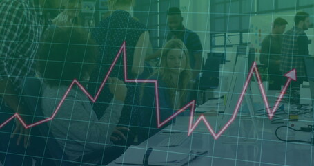 Collaborating office team reviewing data overlay at open-plan workspace, with laptops and notebooks