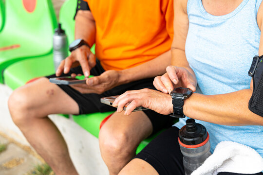 Anonymous mature couple cheking their fitness data on smart devices