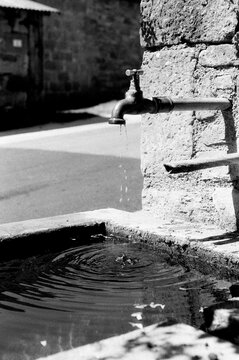 Rustic tap with dripping water in a pond.