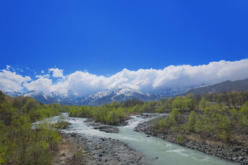 白馬の山と雪解けで濁った川