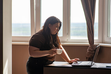 Woman scratching laptop while drinking coffee