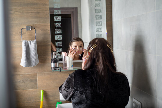 Size plus woman taking care of her face in the bathroom - Powered by Adobe