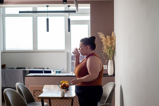 Curve woman takes vitamin tablets and drinks water