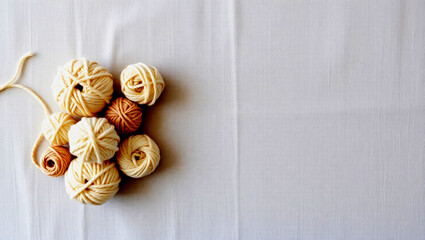 Neutral Yarn Balls on Light Textured Fabric – Corner Flat Lay with Beige and Ivory Tones, Ideal for Crafting, Textile Design, or Background Use