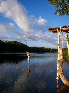 Man jumping into lake from wooden platform