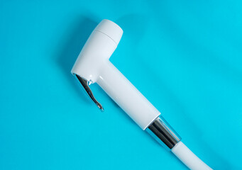 Bidet sprayer or bidet shower, also known as jet toilet shower, bathroom equipment for dispensing water for cleaning purposes, isolated on a blue background.