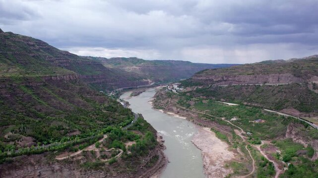 Drone view of yellow river between mountains near Hukou waterfall in Shanxi Province, China, 4k real time footage aerial view.