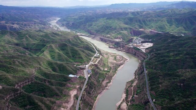 Drone view of yellow river between mountains near Hukou waterfall in Shanxi Province, China, 4k fast motion time lapse footage aerial view.