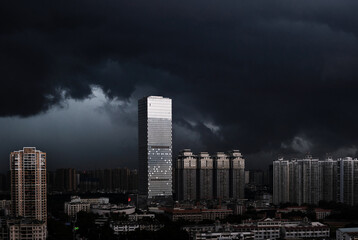 High-rise buildings in the city under the sky with big dark clouds