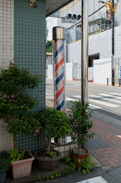 Traditional barber pole outside street corner shop