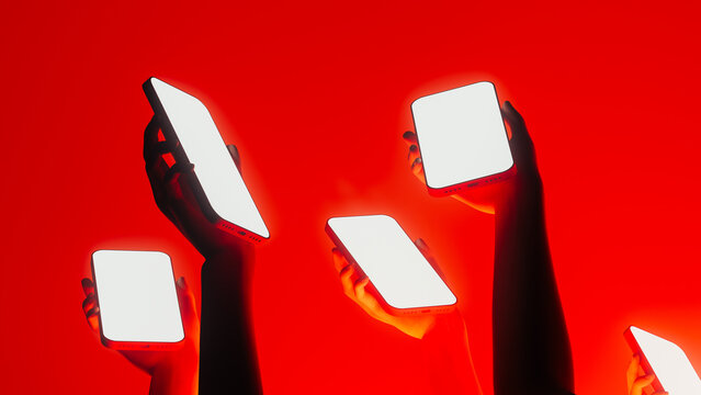 Hands display mobile devices with bright screens in vibrant setting