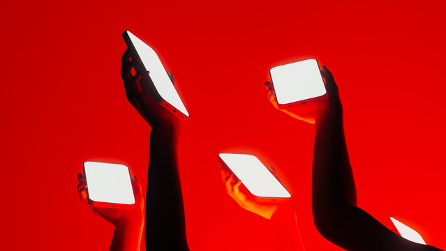 Hands display mobile devices with bright screens in vibrant setting