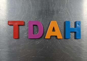TDAH awareness colorful plastic letters on scratched metal surface symbolizing ADHD neurodiversity mental health focus disorder spectrum inclusion and therapy awareness