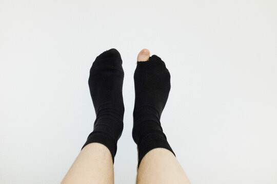 Pov of person wearing socks and having a hole in them and big toe peek