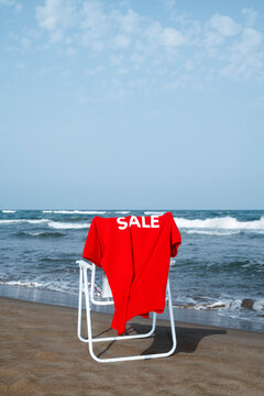 red polo shirt with the word sale on a beach chair