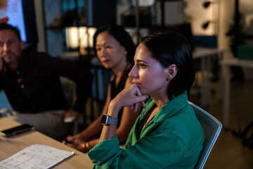 People in a meeting, listening intently during extended office hours