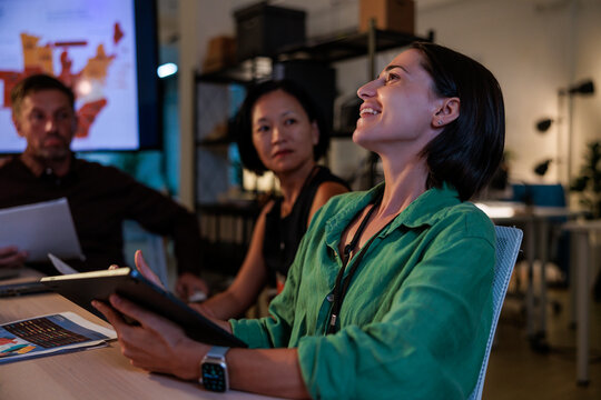 Teamwork, happy woman with tablet in a business meeting, working late