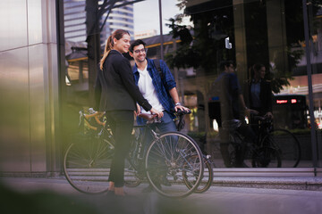 Obraz premium Commuting to work with bicycle. Businessman and businesswoman cycling to office in downtown district. Modern diversity people use eco transportation on city street. Environmental sustainable lifestyle